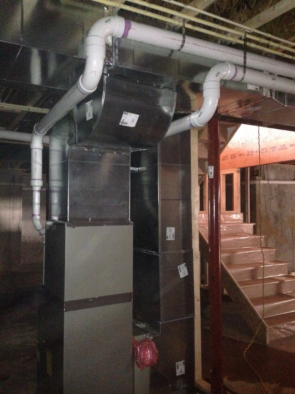 Clean basement mechanical room with new ductwork and piping